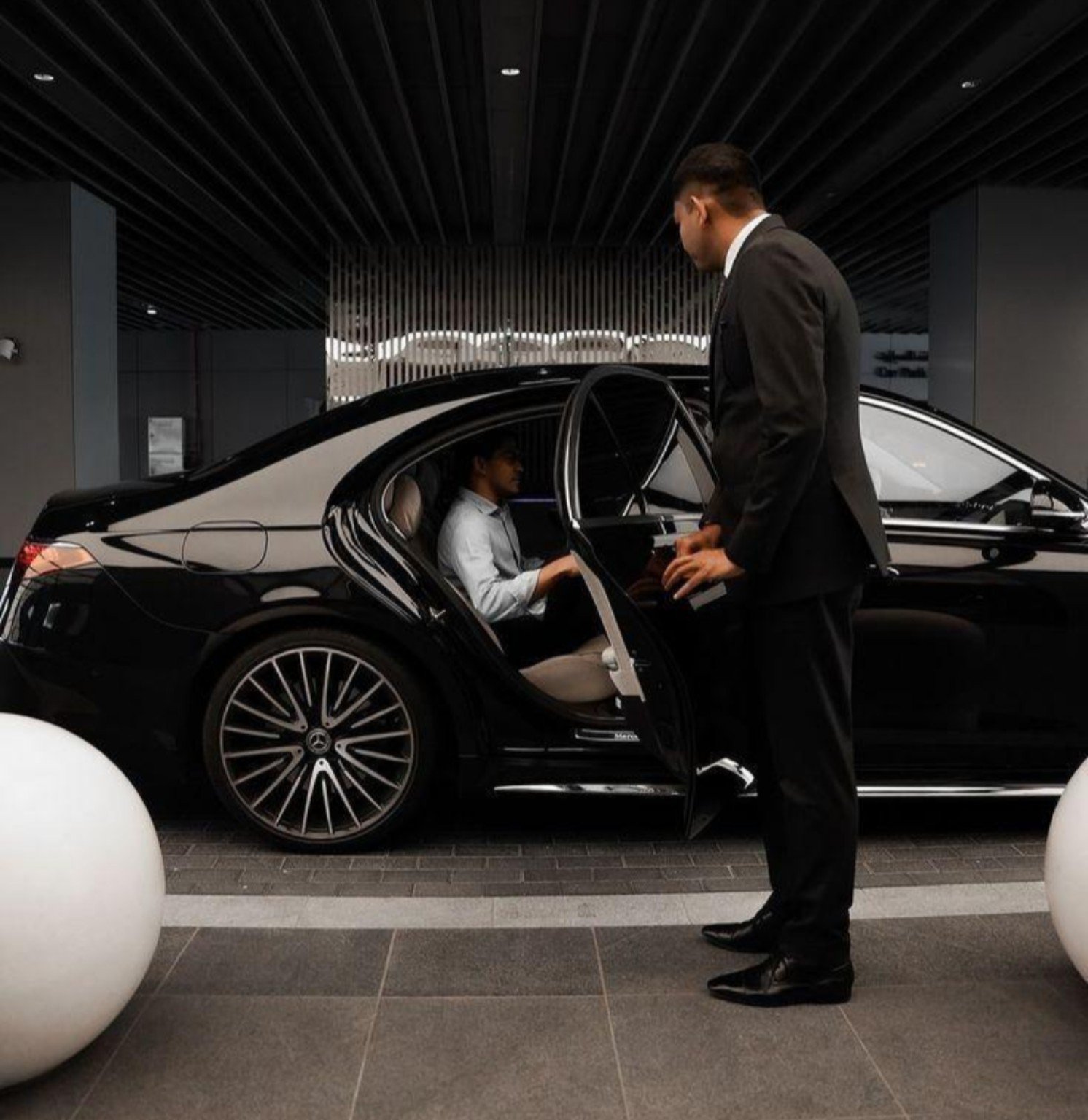 Gidran chauffeur opening a Mercedes passenger door